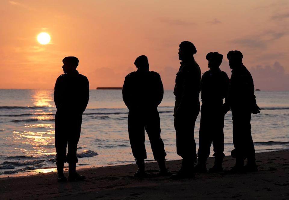 Military reenactors watch the sunrise over Gold Beach in Arromanches-les-Bains, Normandy, on the 81st anniversary of the D-Day landings (Gareth Fuller/PA)