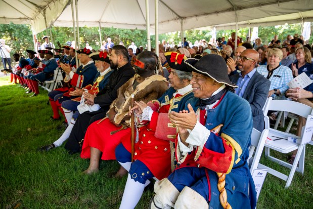 Reenactors applaud during a ribbon-cutting ceremony for a new replica 1738 fort at Fort Mose Historic State Park in St. Augustine on May 9. (Patrick Connolly/Orlando Sentinel)