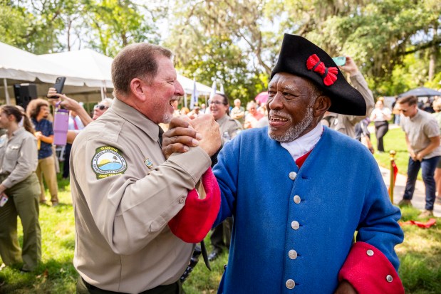Charles Ellis, right, president of the Fort Mose Historical Society, celebrates with Florida State Parks Director Chuck Hatcher during a ribbon-cutting ceremony for a new replica 1738 fort at Fort Mose Historic State Park in St. Augustine on May 9. (Patrick Connolly/Orlando Sentinel)